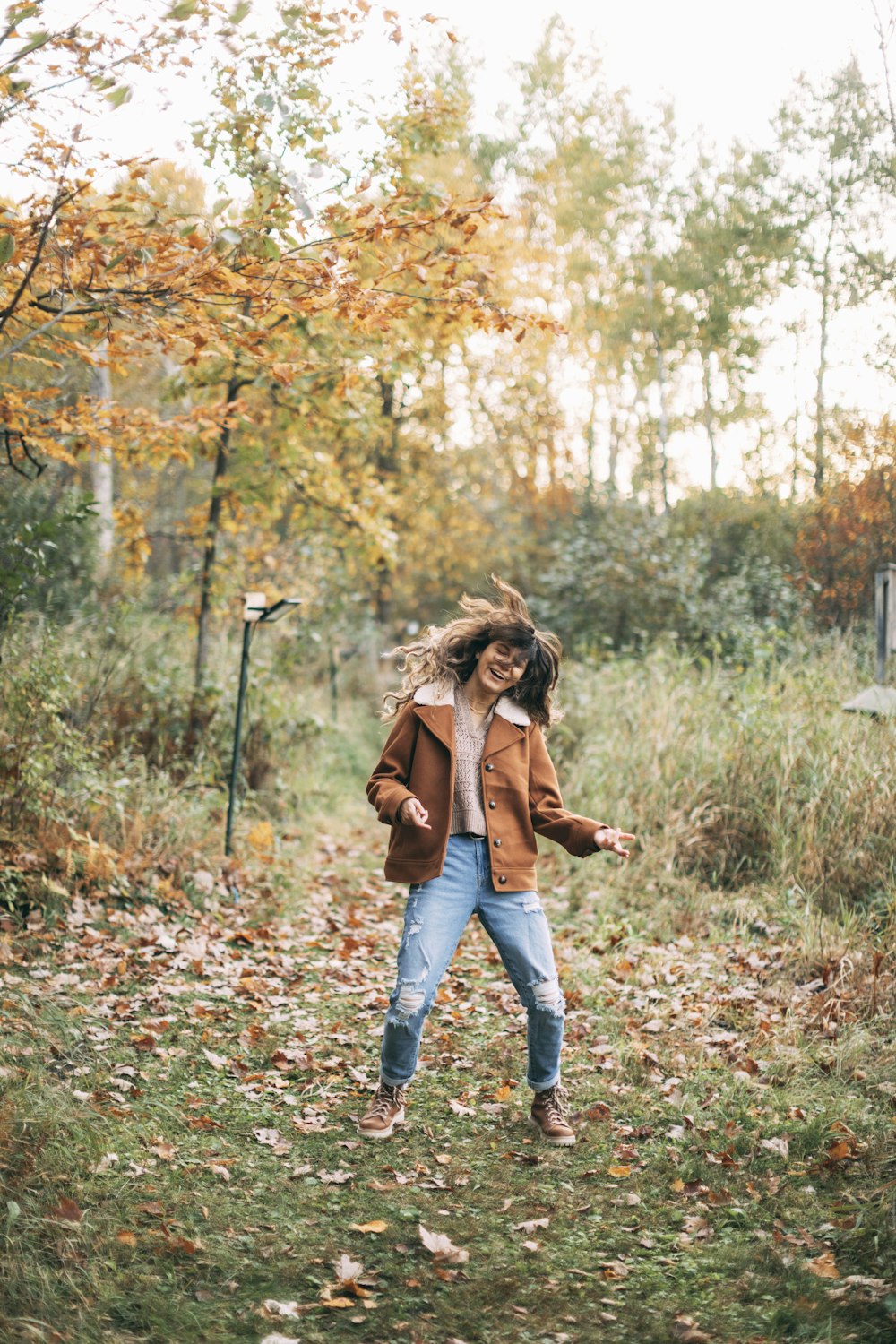 a woman standing in a field with her hair blowing in the wind