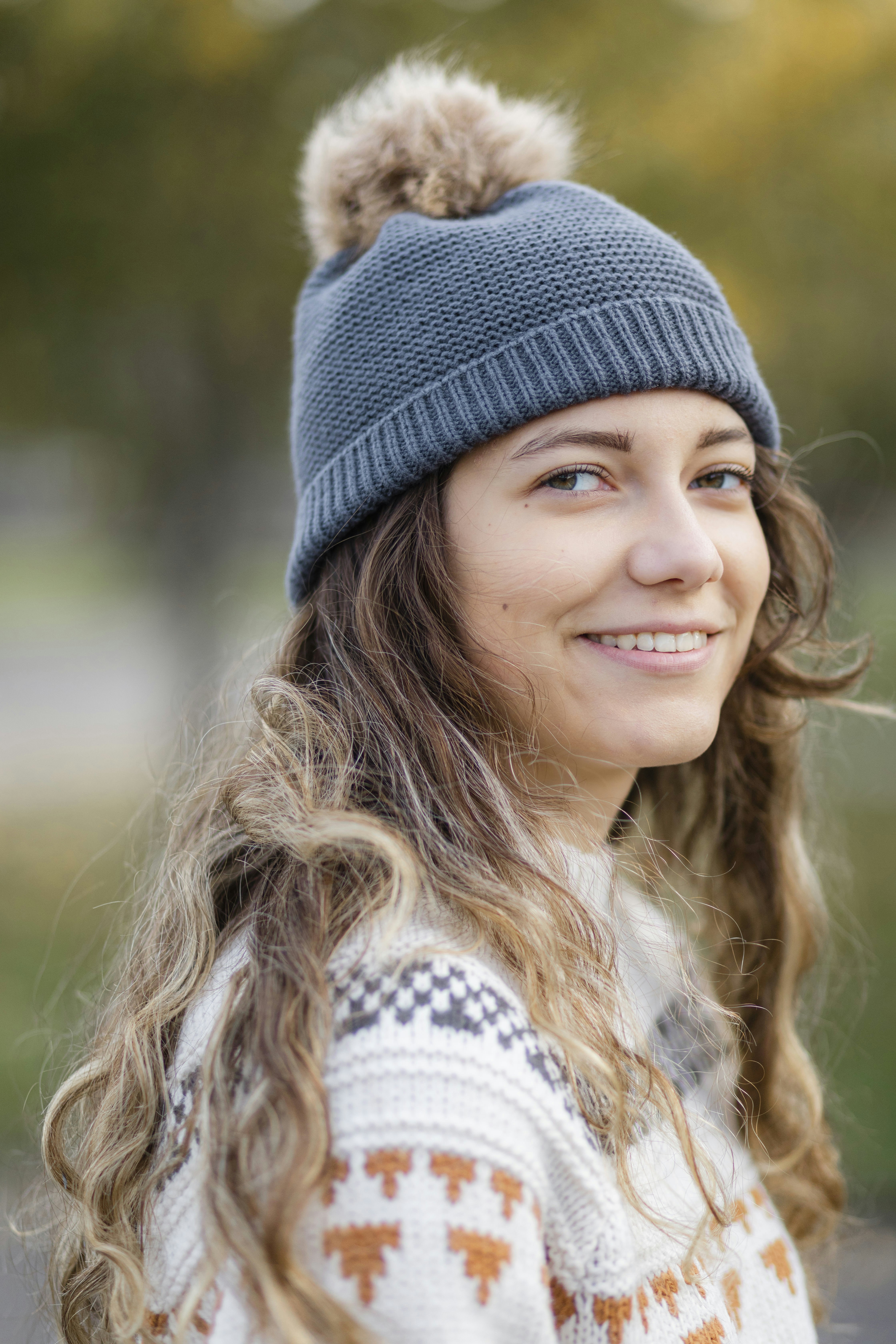a woman with long hair wearing a blue hat