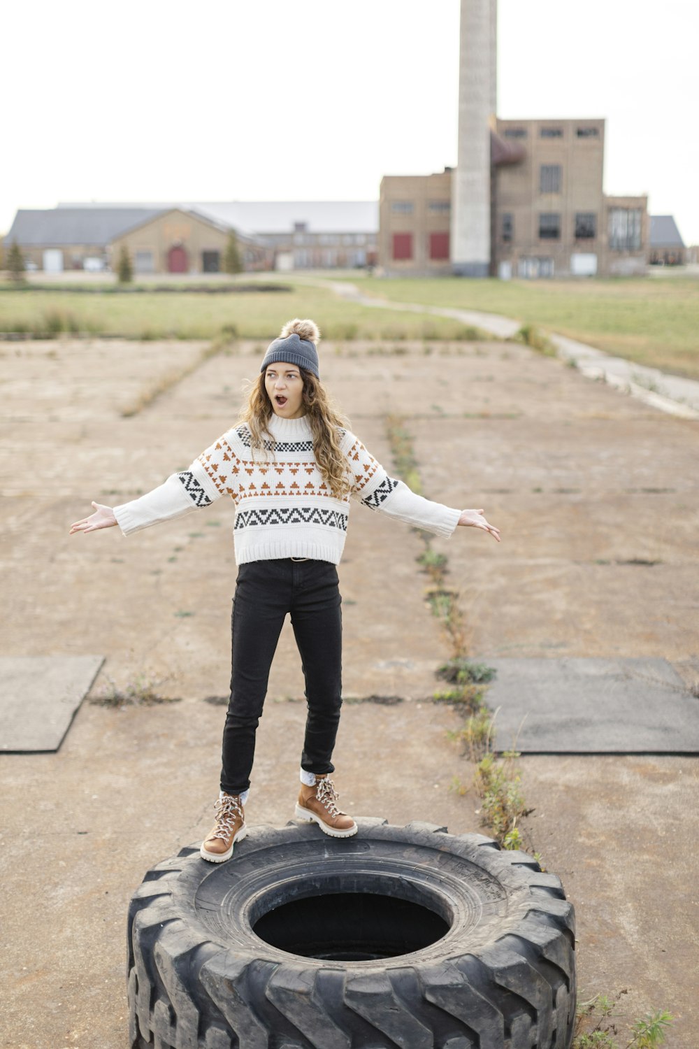 a woman standing on top of a tire in a parking lot