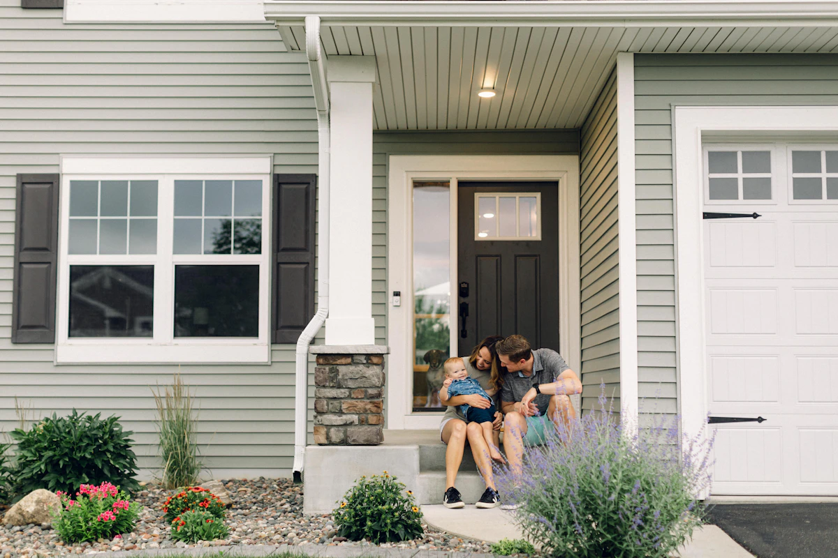 Happy family sitting together on the porch of their new Perth home