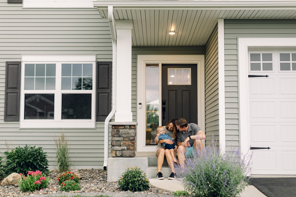 a couple of people that are sitting in front of a house