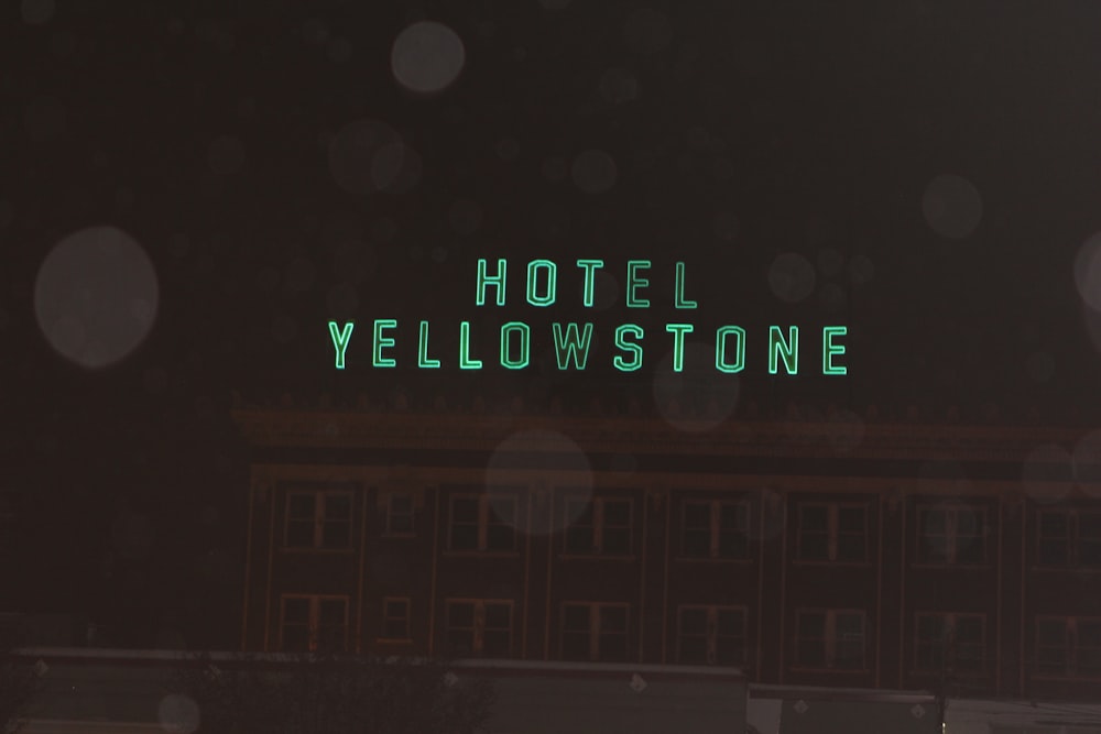 the words hotel yellowstone are written in green