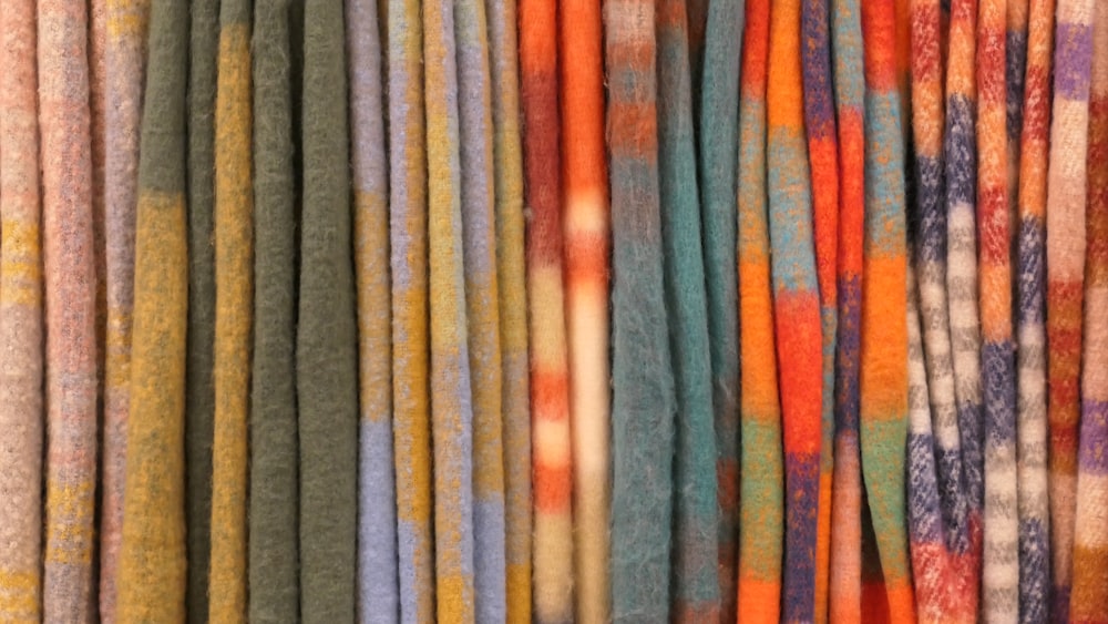 a bunch of different colored fabrics hanging on a wall