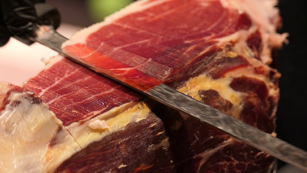 a close up of meat being cut with a knife
