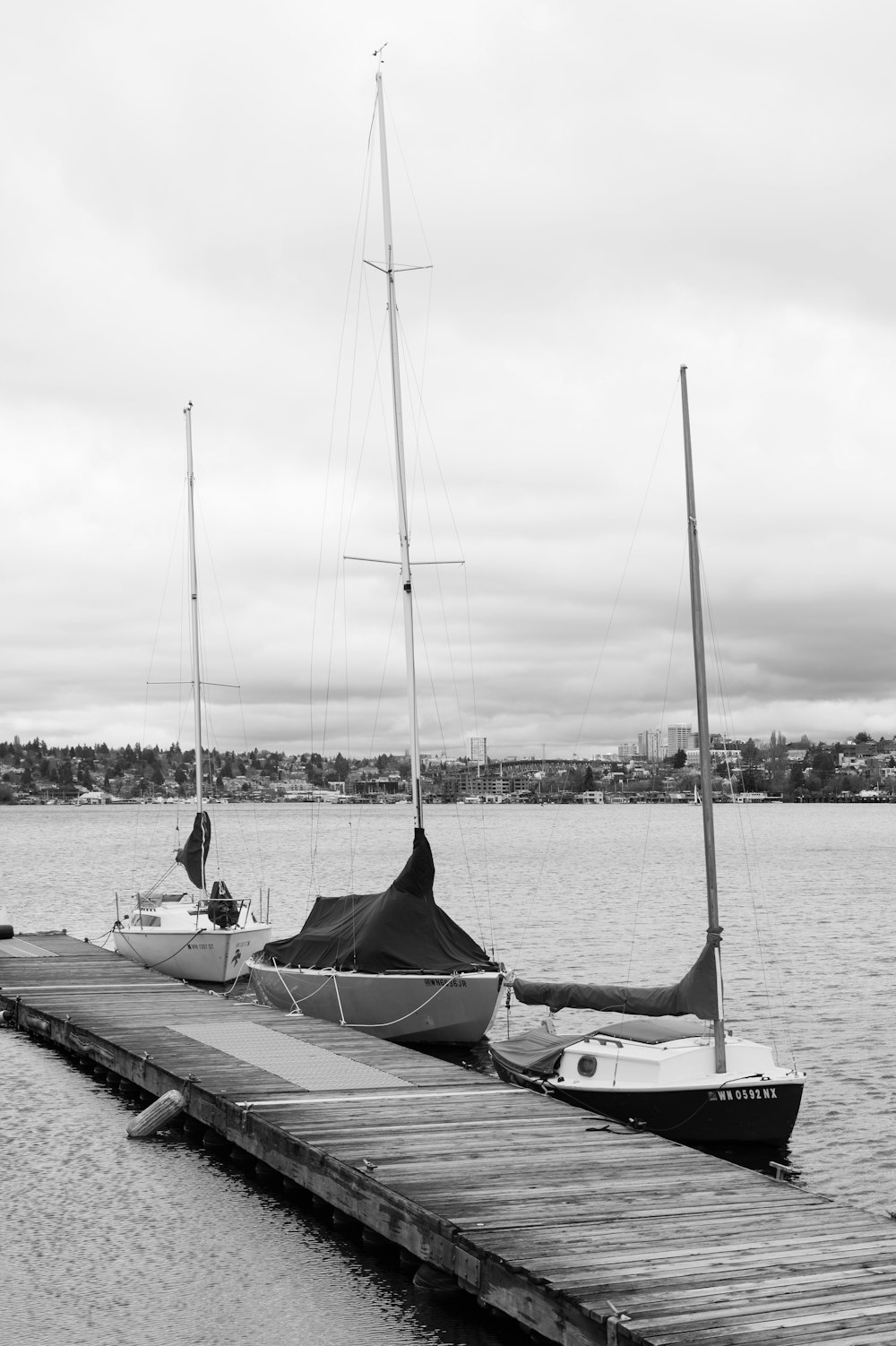 a black and white photo of a boat docked at a pier