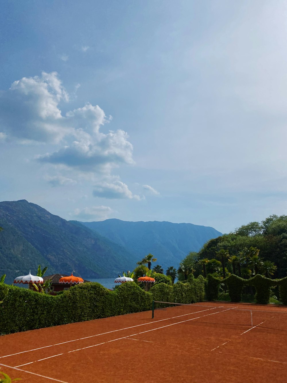 a tennis court with mountains in the background