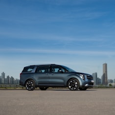 a silver car parked in front of a city skyline
