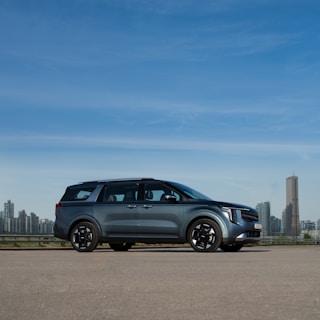 a silver car parked in front of a city skyline