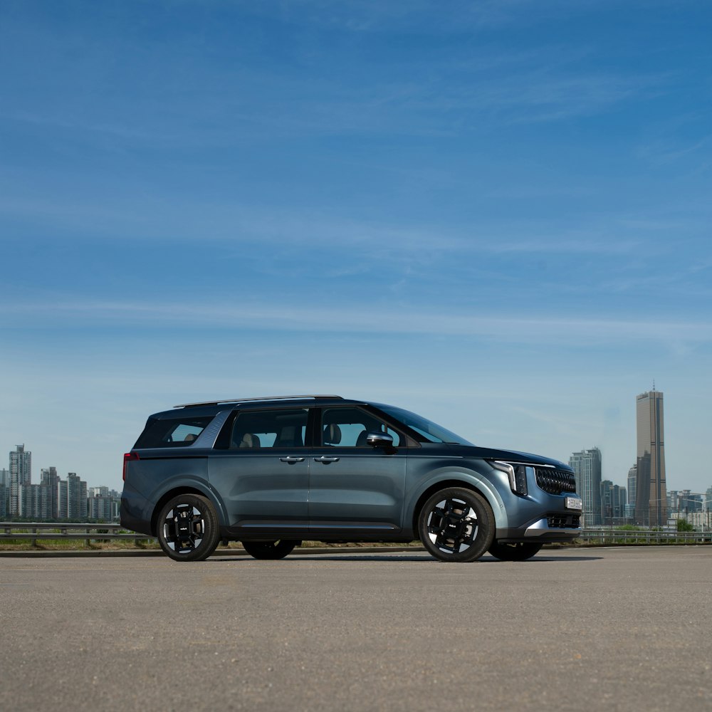 a silver car parked in front of a city skyline