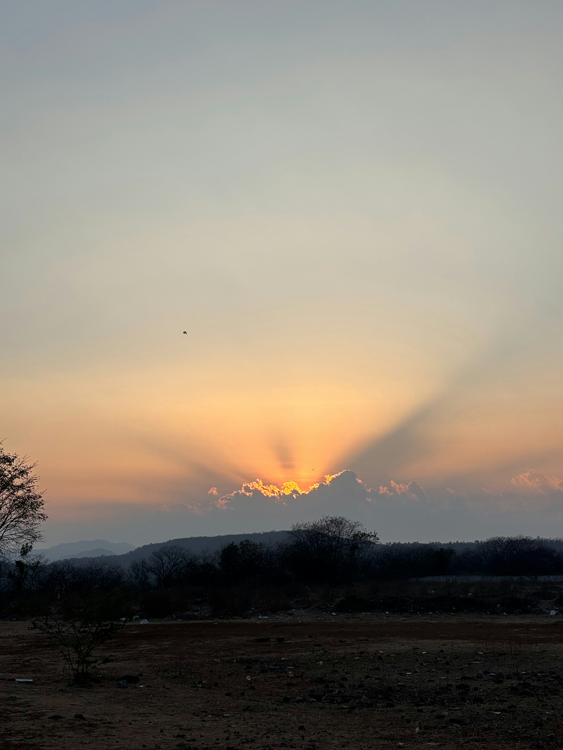 the sun is setting over the mountains in the distance
