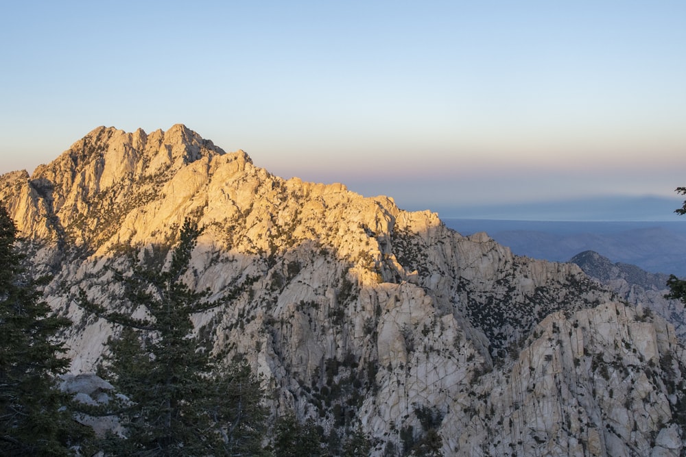 a view of the top of a mountain at sunset