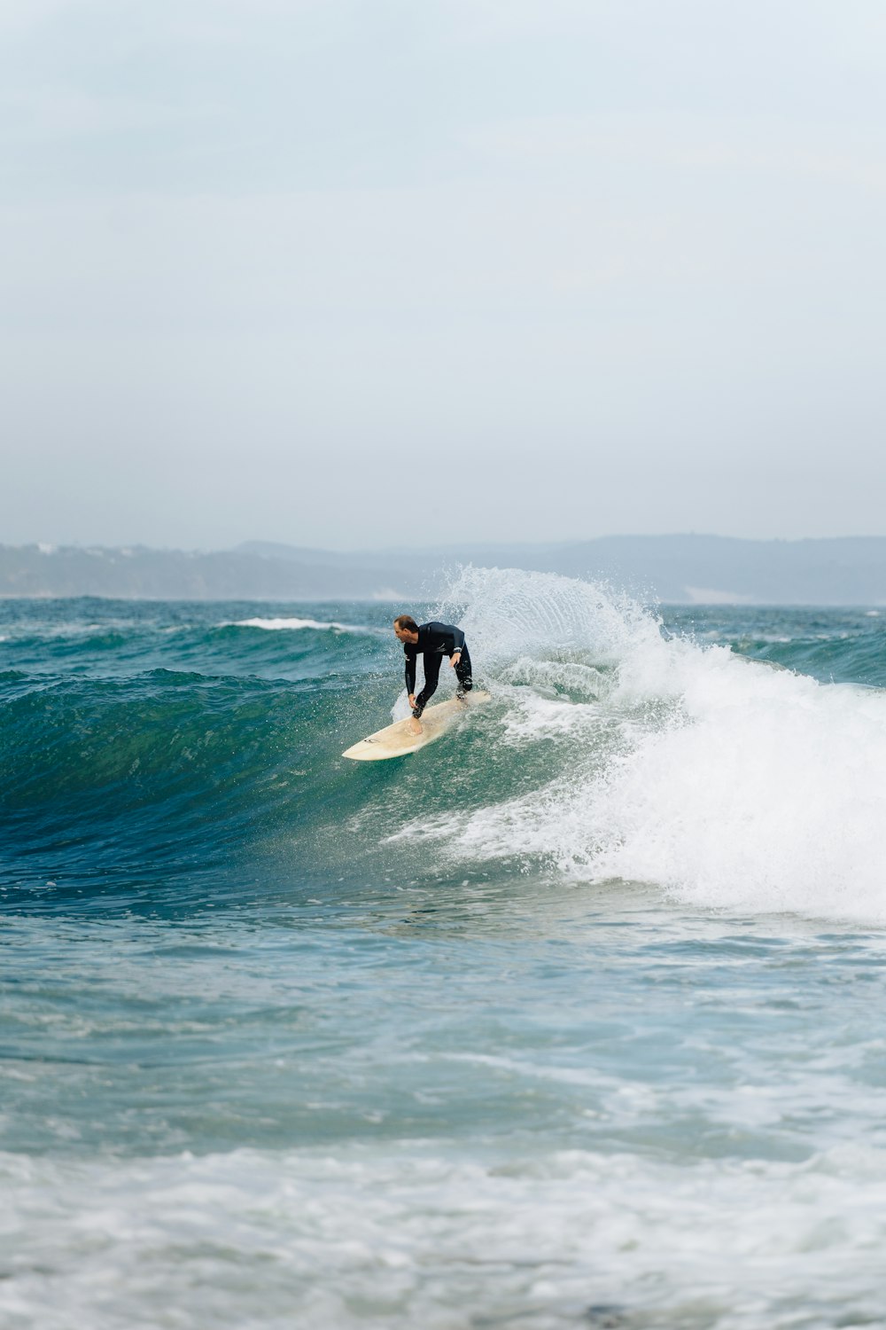 a man riding a wave on top of a surfboard