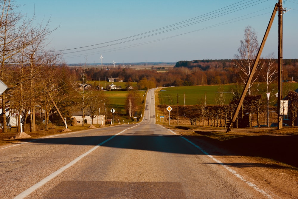 an empty road in the middle of a rural area