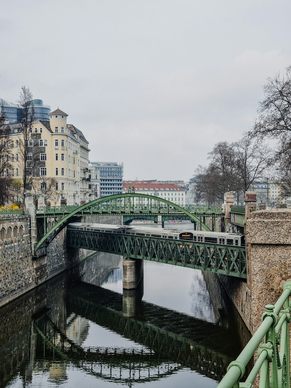 a bridge over a body of water with buildings in the background