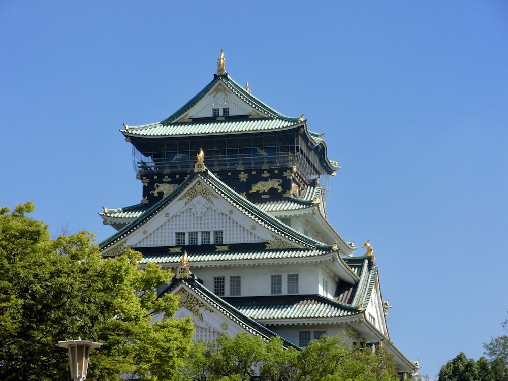 a tall white building with a green roof