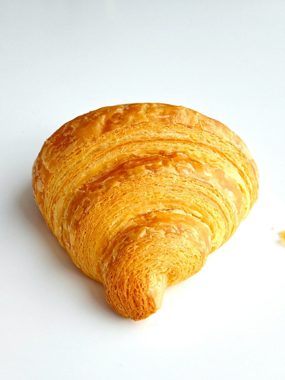 a close up of a croissant on a white surface