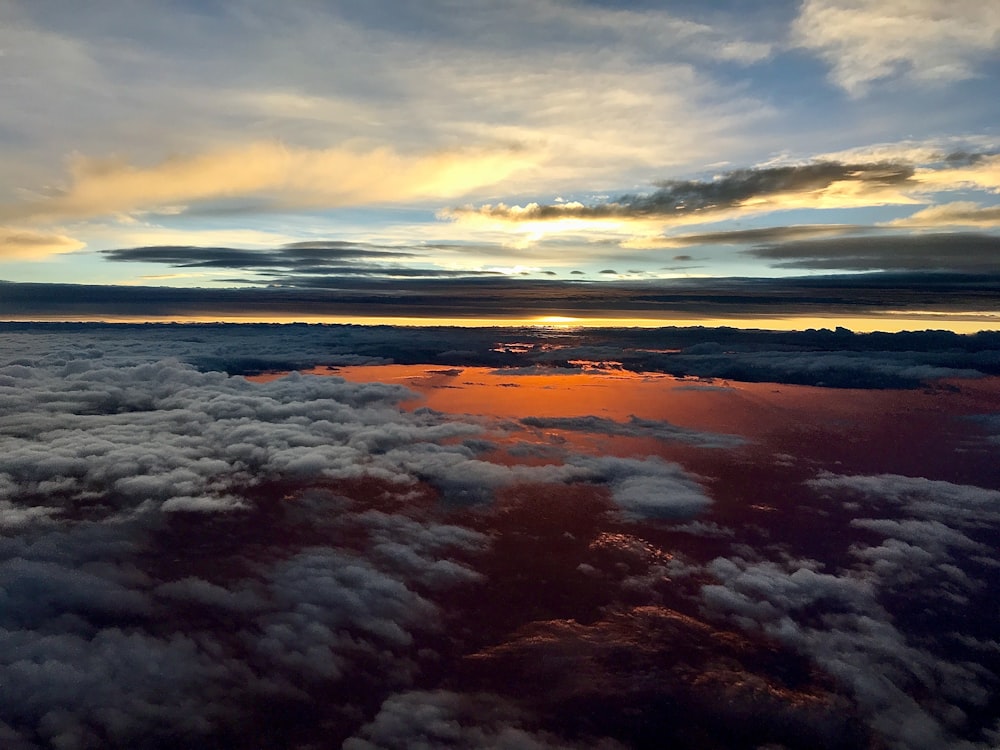 the sun is setting over the clouds in the sky