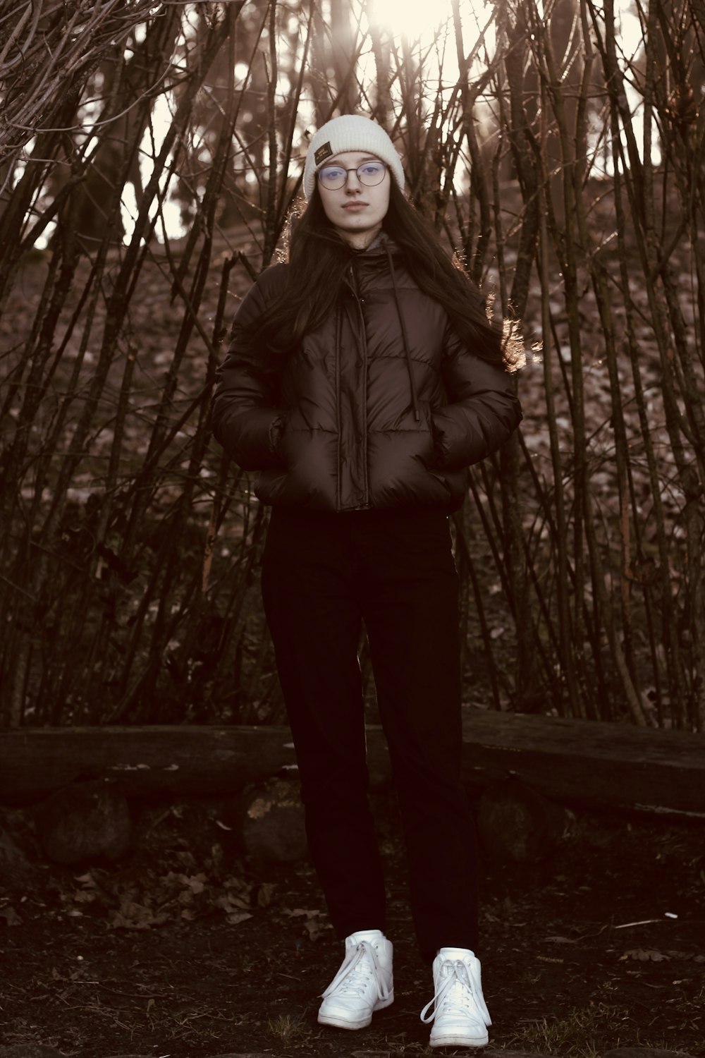 a woman standing in front of a bunch of trees