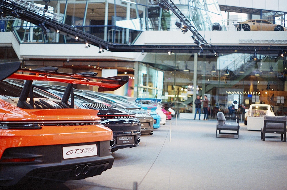 a bunch of cars are parked in a showroom
