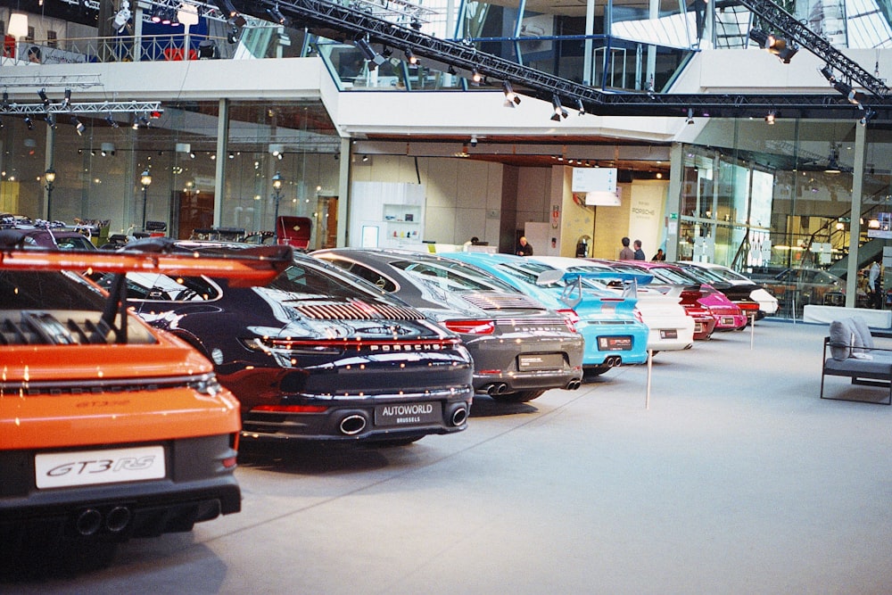 a bunch of cars are parked in a showroom