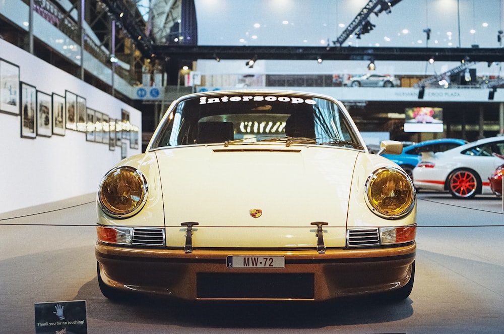 a white car is on display in a museum