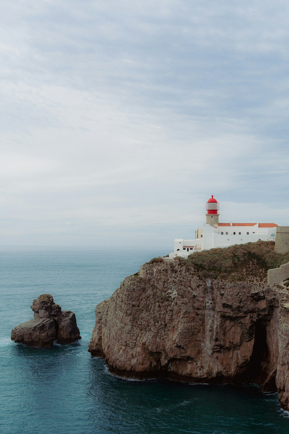 a lighthouse on top of a cliff near the ocean