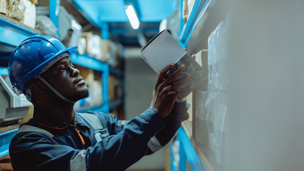 a man in a hard hat is looking at a piece of paper