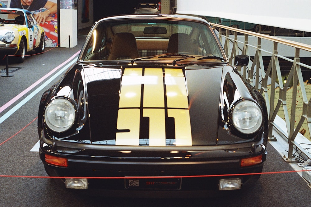 a black car with a yellow stripe parked in a garage