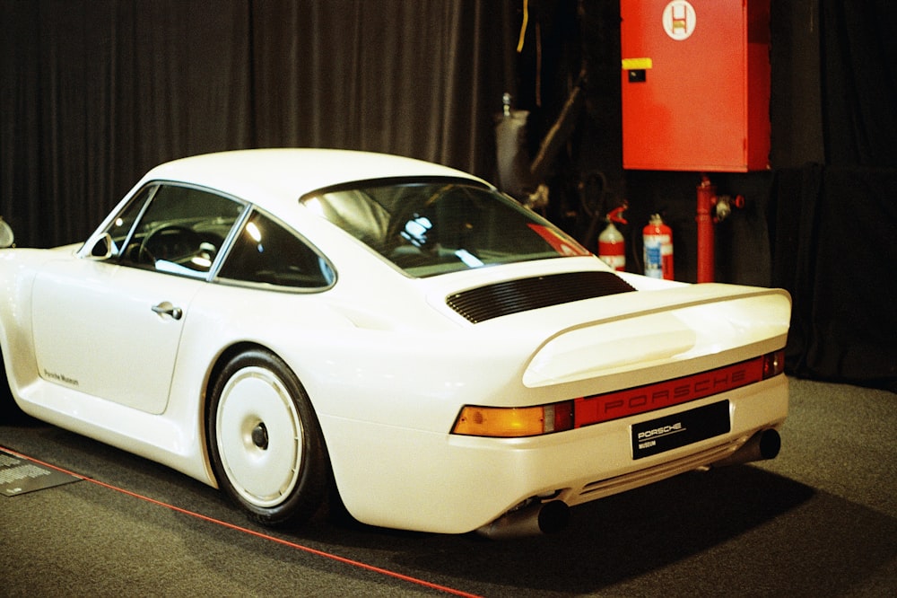 a white sports car on display at a car show