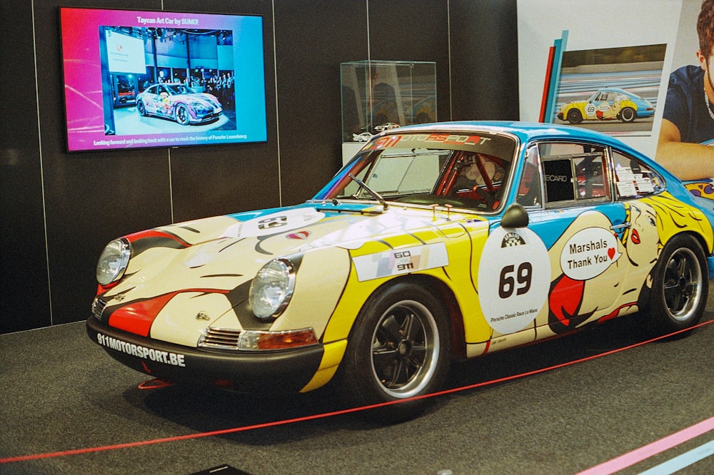 a man standing next to a colorful car on display