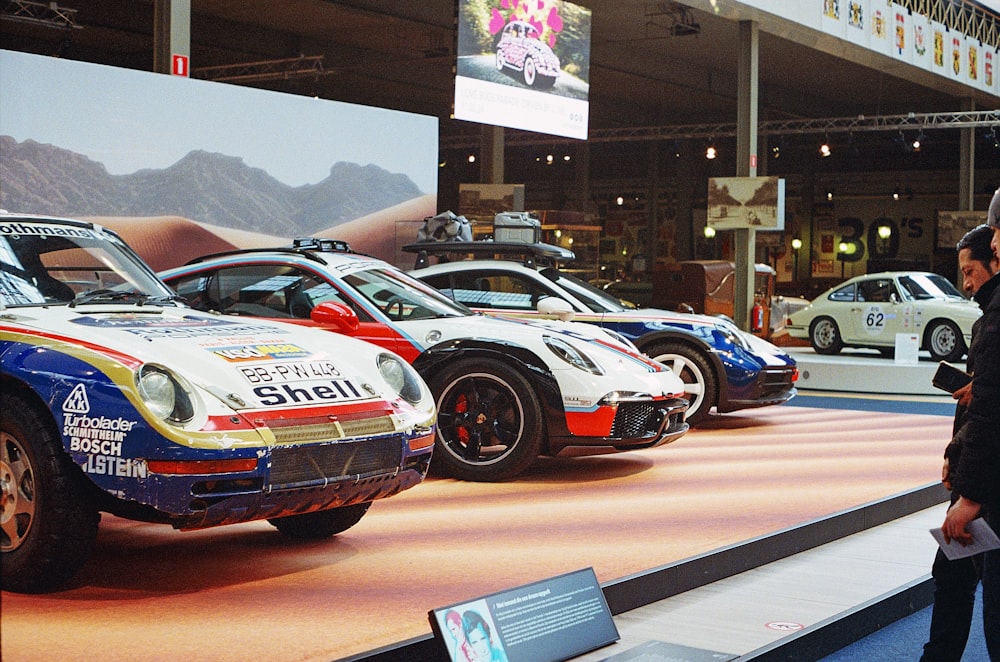 a man standing in front of a display of race cars