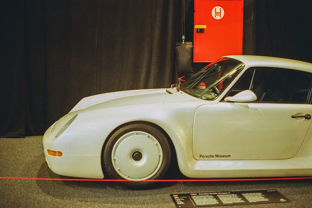 a white sports car on display in a museum