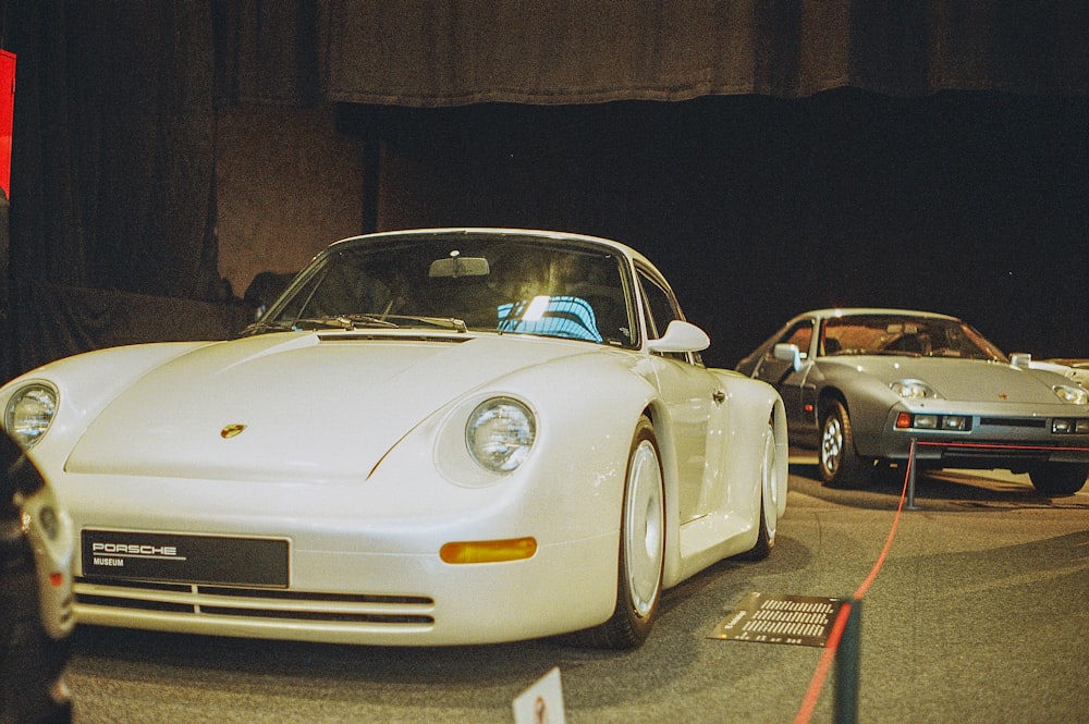 a white sports car on display in a museum