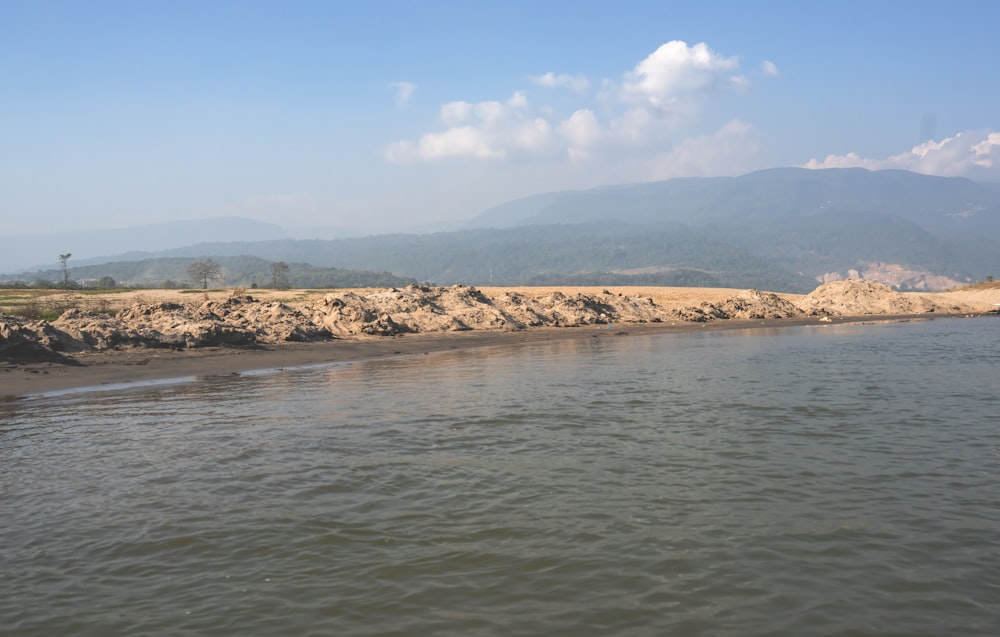 a body of water with mountains in the background