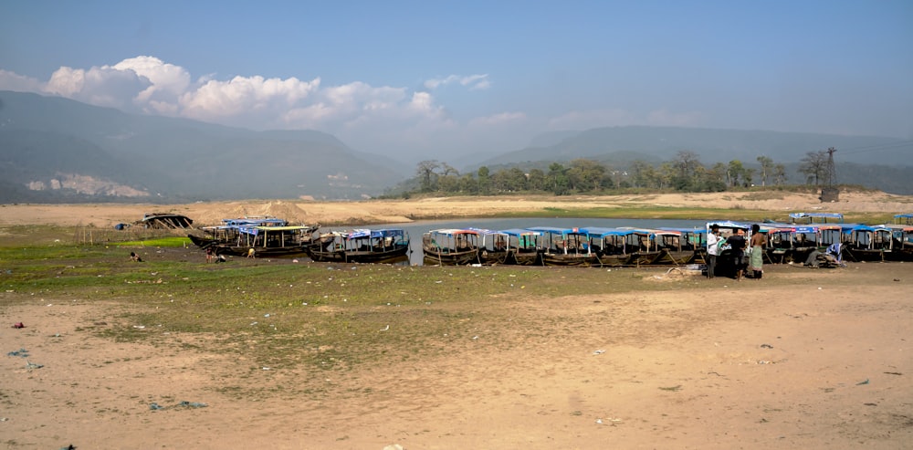a group of boats sitting on top of a dry grass field