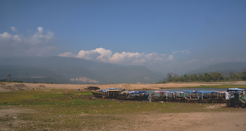 a group of boats sitting on top of a dry grass field
