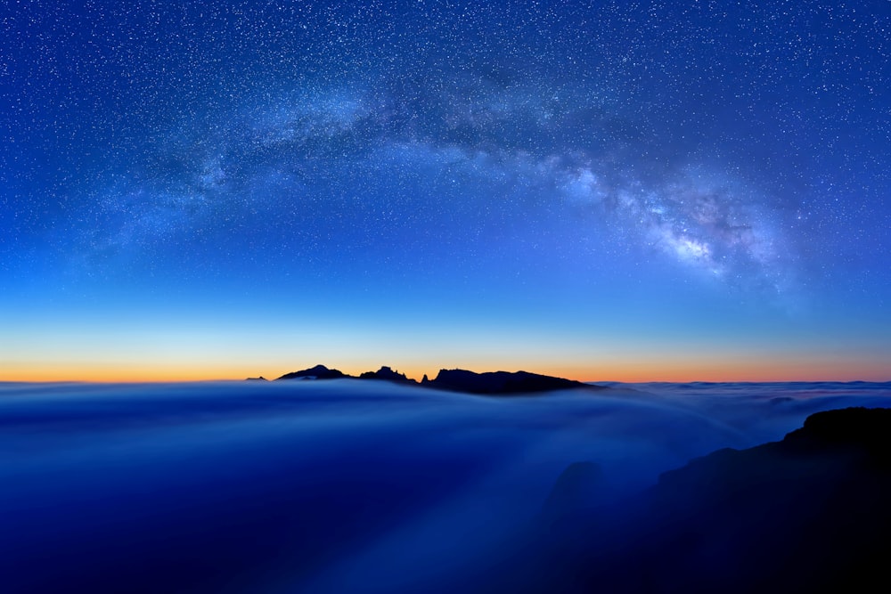a view of the night sky with the milky in the distance