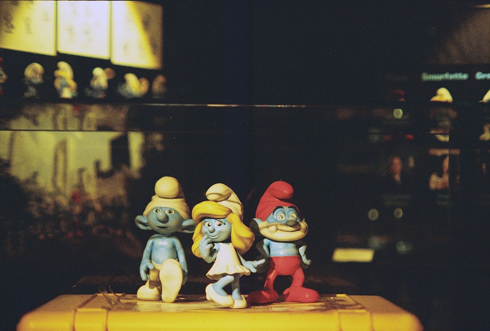 un groupe de figurines posées sur une boîte jaune