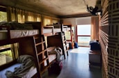 a room filled with lots of bunk beds next to a window
