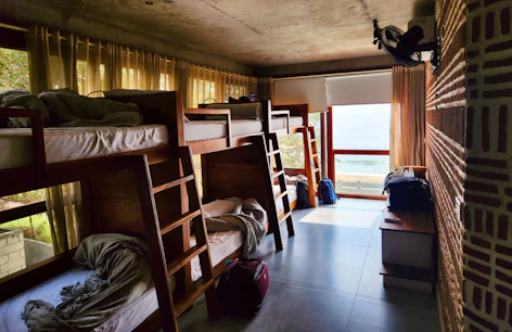a room filled with lots of bunk beds next to a window