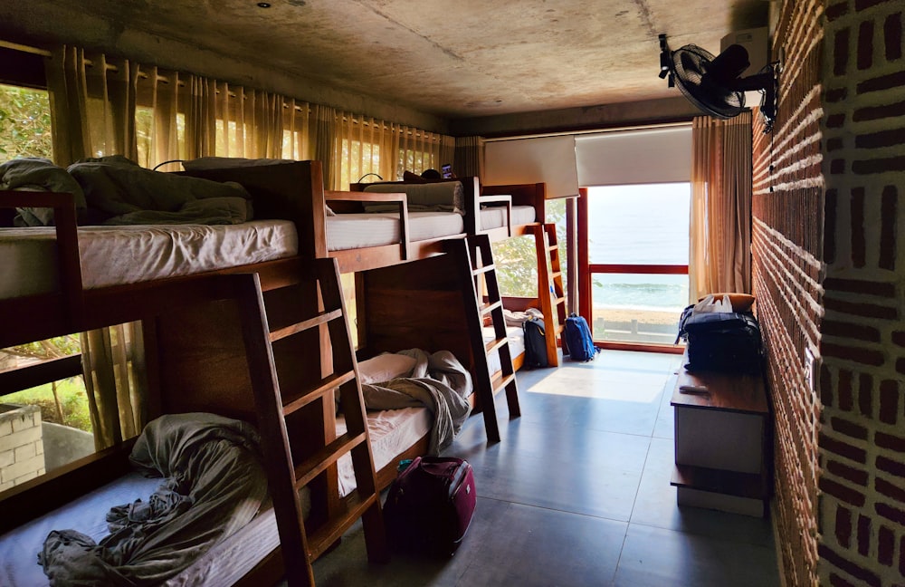 a room filled with lots of bunk beds next to a window