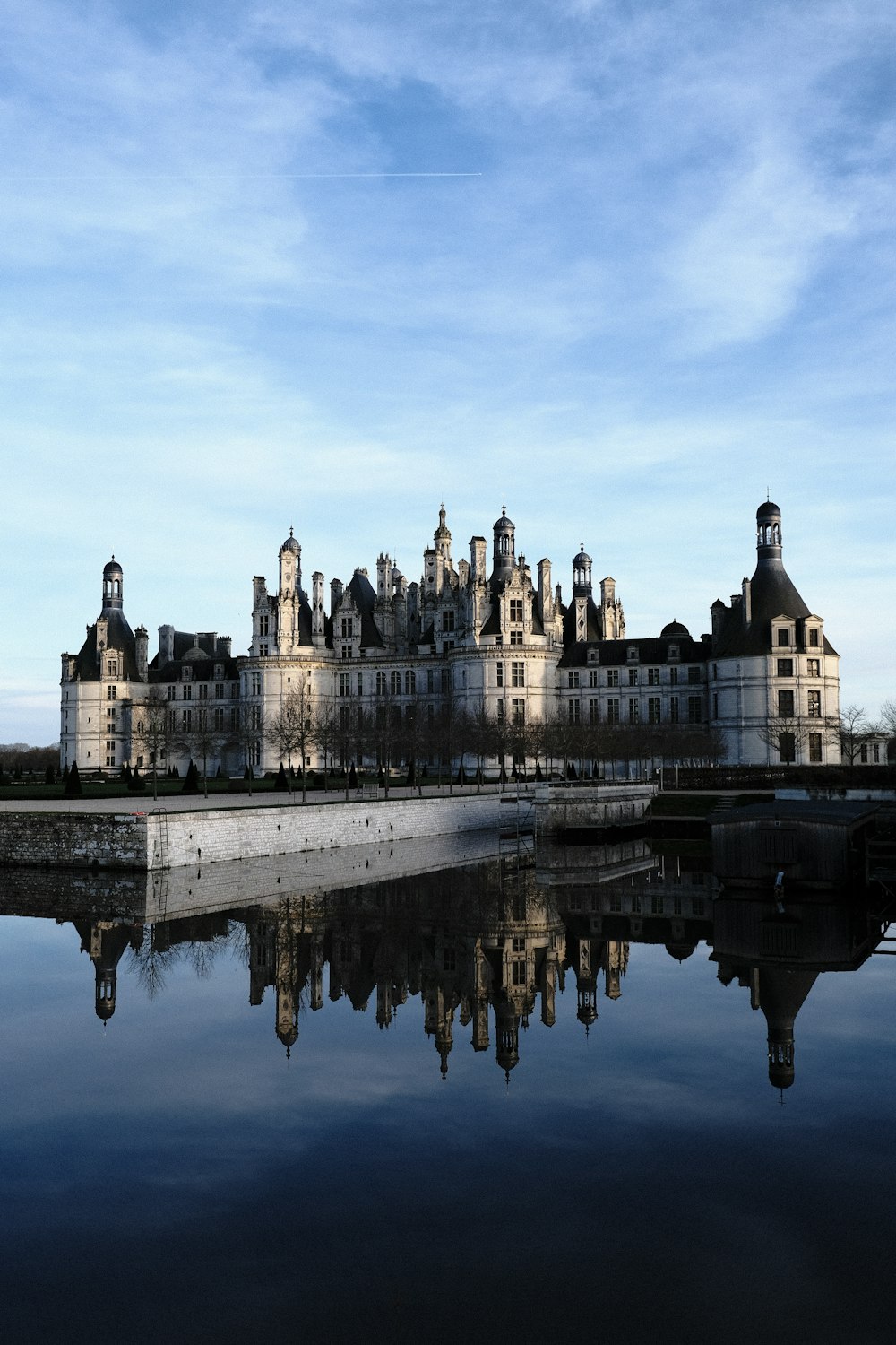 a large building with a clock tower next to a body of water