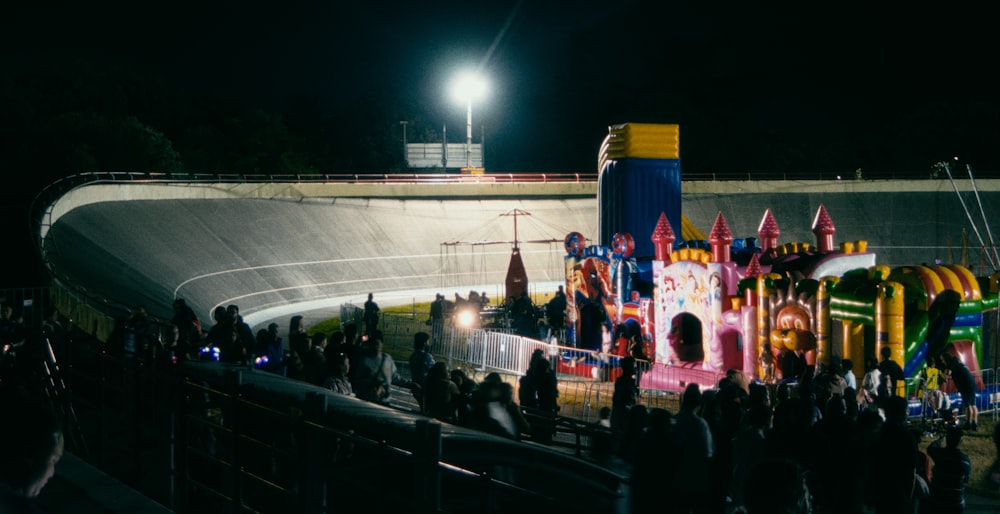 a crowd of people standing around a carnival ride