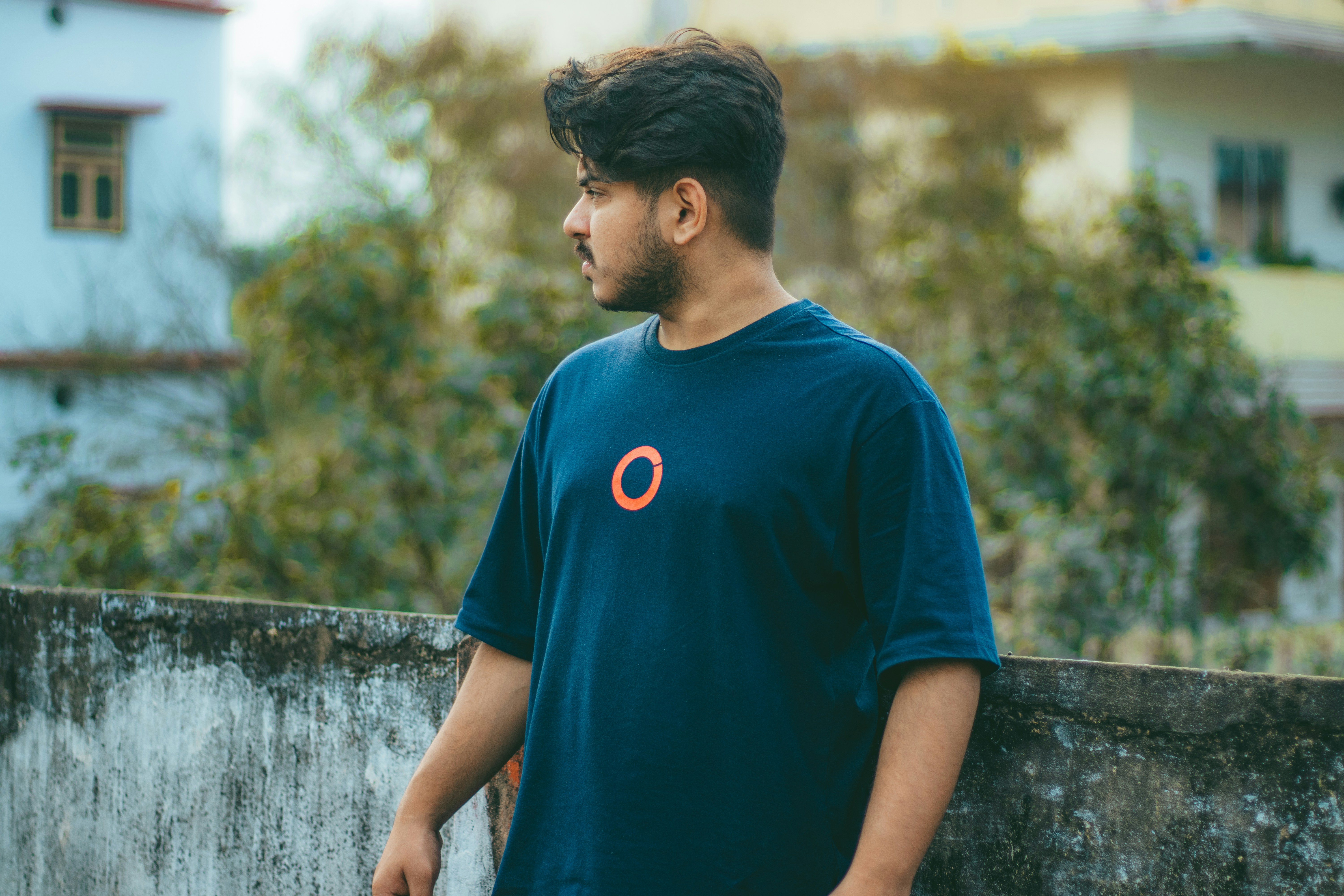 a man standing next to a cement wall