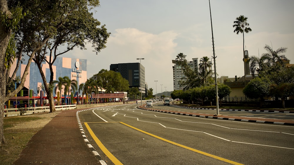 a city street with palm trees and buildings in the background