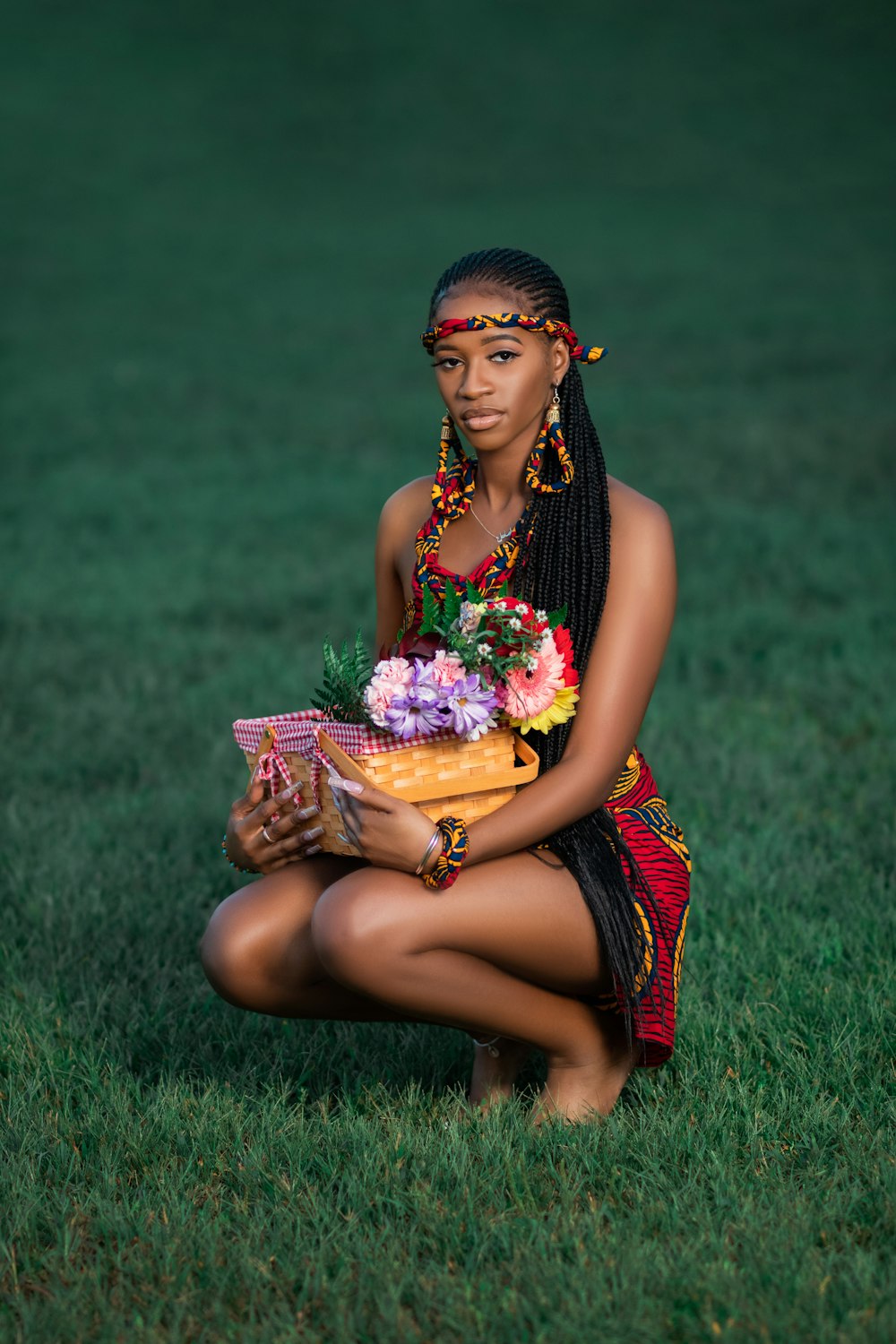 a woman sitting in the grass holding a basket of flowers
