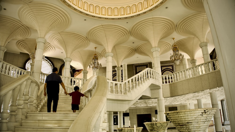 a man and a child are walking up the stairs