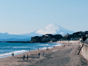 a group of people standing on top of a sandy beach