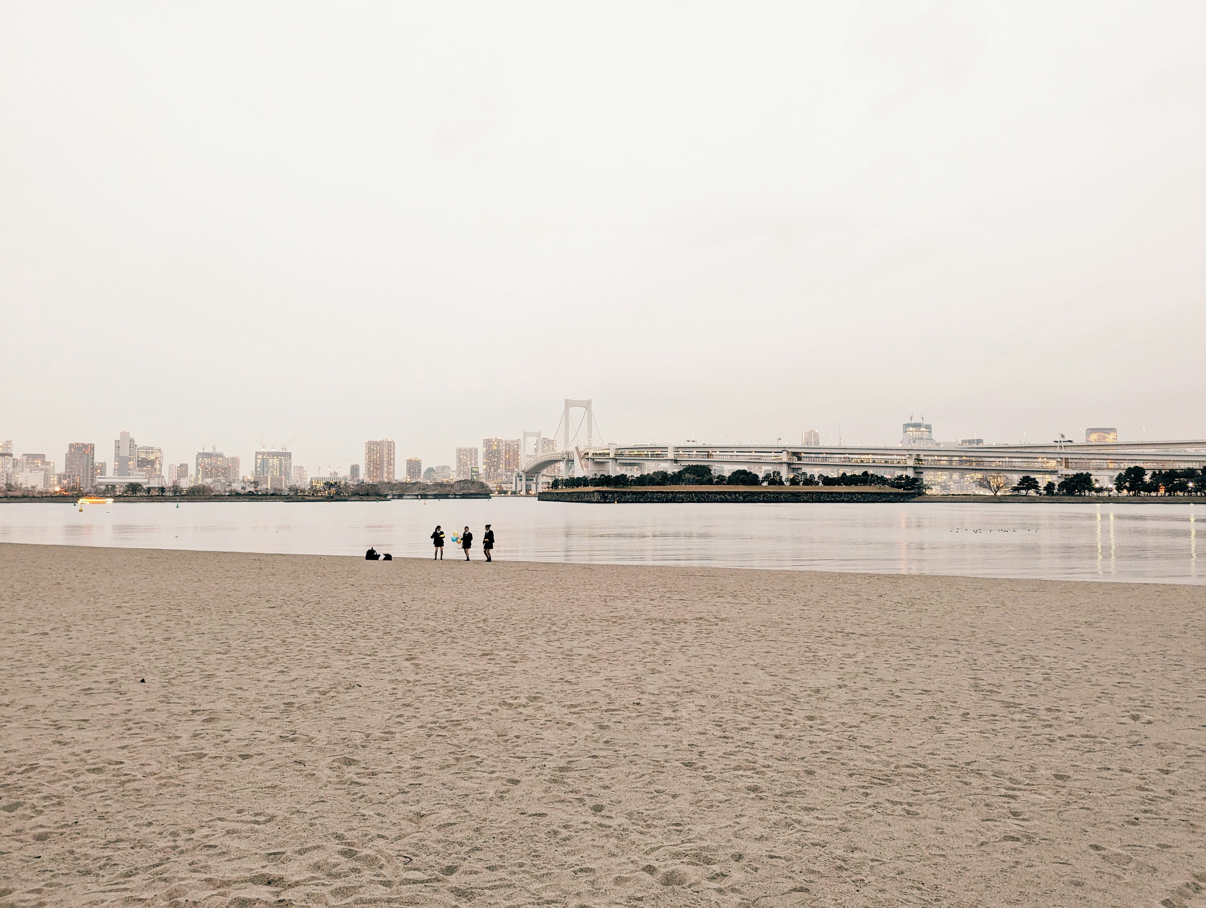 a group of people standing on top of a sandy beach