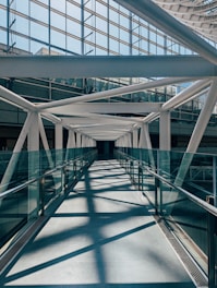 a long walkway with metal railings leading to a building
